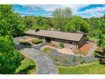 Ranch style home with gorgeous landscaping, trees, and driveway at 4701 Homestead St, Bow Mar, CO 80123