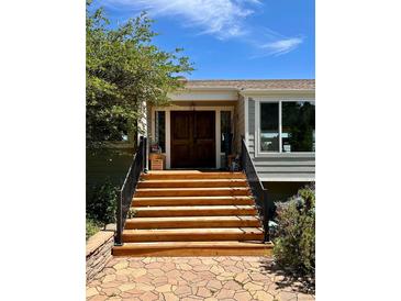 Inviting front entrance featuring a wooden door and a series of wooden steps at 6943 Fox Cir, Larkspur, CO 80118