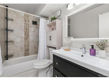 Bright bathroom featuring tiled walls, updated vanity, and shower-tub combination at 6940 E Girard Ave # 210, Denver, CO 80224
