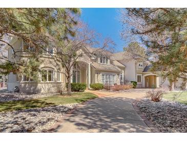 Elegant two-story home featuring a brick driveway, manicured lawn, and charming architectural details at 7 Mockingbird Ln, Cherry Hills Village, CO 80113