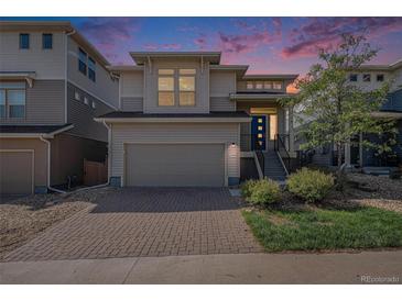 Beautiful two story home with brick driveway, garage and modern architecture under a vibrant sunset sky at 3116 Jonquil St, Castle Rock, CO 80109