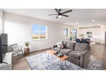 Bright living room featuring modern decor, a large window, and an open layout at 5805 Red Barn Ave, Mead, CO 80504