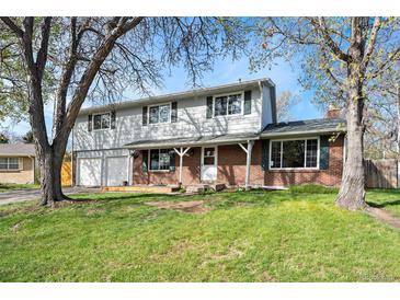 Charming two-story home with a brick and siding facade, two-car garage, and a covered front porch at 6323 W 85Th Ave, Arvada, CO 80003