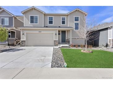 Charming two-story home features a well-manicured lawn, a two-car garage, and stone accents at 21650 E Tufts Cir, Aurora, CO 80015
