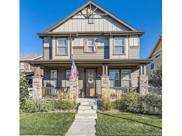 Charming two-story home featuring a welcoming front porch and well-maintained landscaping at 21851 E Tallkid Ave, Parker, CO 80138