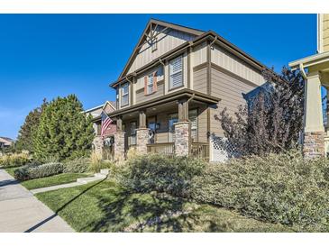 Charming two-story home featuring a welcoming front porch and well-maintained landscaping at 21851 E Tallkid Ave, Parker, CO 80138