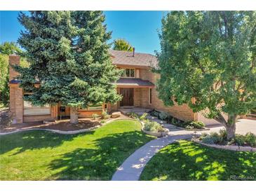 Charming brick home featuring lush landscaping and a curved walkway leading to the front entrance at 8136 S Glencoe Ct, Centennial, CO 80122