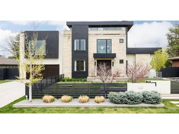 Modern two-story home boasting stone and black paneling, manicured landscaping, and a horizontal black fence at 140 S Glencoe St, Denver, CO 80246