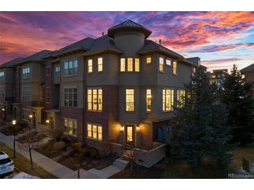 Stunning multi-story townhome with beautiful architectural details and an eye-catching sunset backdrop at 7821 Inverness Blvd, Englewood, CO 80112