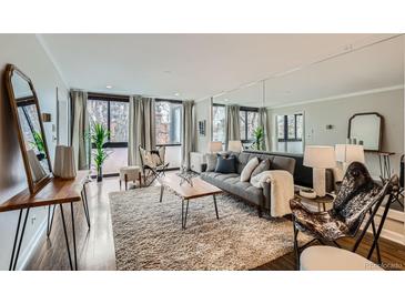Bright living room with expansive windows, hardwood floors, and stylish contemporary furniture at 1050 N Corona St # 304, Denver, CO 80218