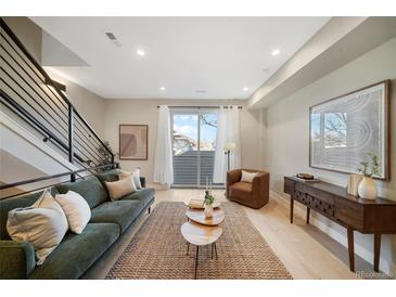 Cozy living room featuring a modern staircase, stylish furniture, and sliding glass doors to a balcony at 1473 N Locust St, Denver, CO 80220