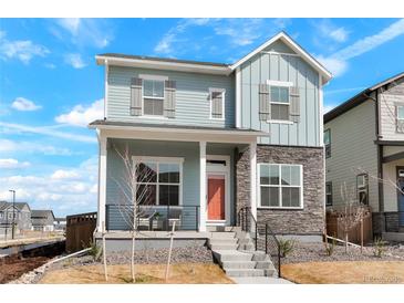 Charming two-story home featuring stone accents, a welcoming front porch, and a well-manicured yard at 21209 E 62Nd Ave, Aurora, CO 80019