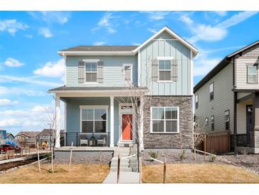 Charming two-story home featuring stone accents, covered porch, and inviting orange front door at 21209 E 62Nd Ave, Aurora, CO 80019