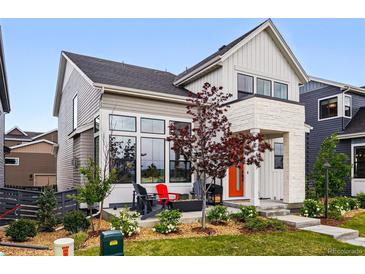 Charming home with an orange front door, covered porch, and well-manicured landscaping at 6237 Stable View St, Castle Pines, CO 80108