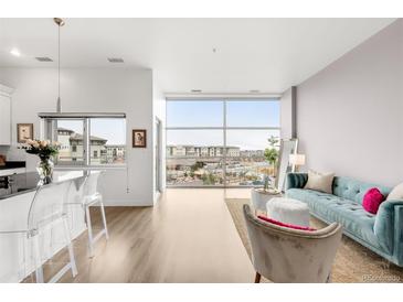 Open floor plan with a living room area bathed in natural light from expansive windows at 2958 Syracuse St # 412, Denver, CO 80238