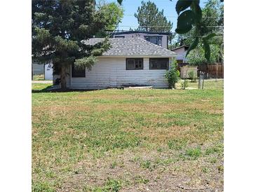 A single-story home features white siding and a well-maintained lawn at 256 S 2Nd Ave, Brighton, CO 80601