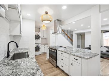 Bright kitchen featuring stainless appliances, granite countertops, and convenient washer/dryer hookups at 7995 E Mississippi Ave # A4, Denver, CO 80247