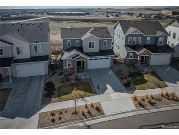 Charming two-story home with stone accents, a well-manicured lawn, and an attached two-car garage in a desirable neighborhood at 15076 W 93Rd Ave, Arvada, CO 80007
