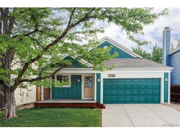 Charming home featuring a lovely porch, two-car garage, and lush green lawn at 7680 Elmwood St, Littleton, CO 80125