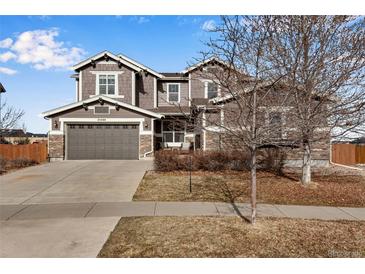 Inviting two-story home featuring a two-car garage and a blend of stone and siding accents at 25669 E Fair Dr, Aurora, CO 80016