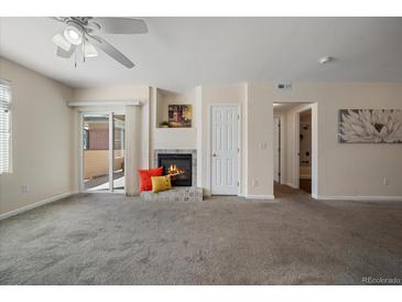 Bright living room with fireplace and sliding glass door to patio at 750 Copper Ln # 102, Louisville, CO 80027