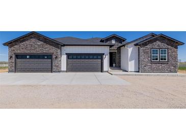 Charming new home features stone accents, three-car garage, and sleek modern design at 56159 E Tomahawk Ave, Strasburg, CO 80136