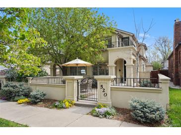 Charming home featuring a gated courtyard with lush landscaping and inviting outdoor living space at 520 Jackson St, Denver, CO 80206