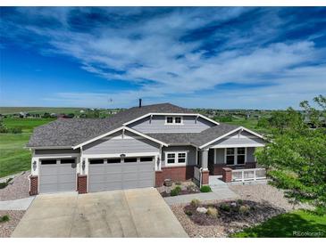 Charming home with a three-car garage and beautiful landscaping under a sunny blue sky at 2504 Elkhorn Ranch St, Parker, CO 80138