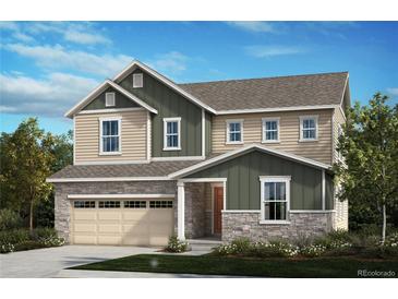 Charming two-story home with stone accents, a two-car garage, and a well-manicured lawn at 20633 E 57Th Ave, Aurora, CO 80019