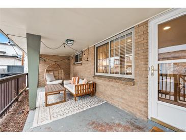 Cozy covered porch featuring a unique egg chair, stylish seating, and a patterned rug on the floor at 2461 Yates St, Denver, CO 80212
