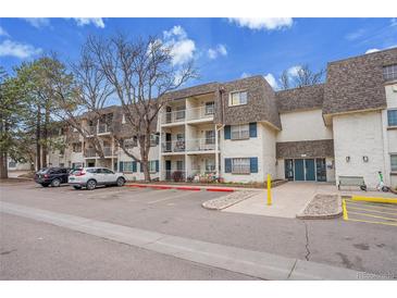 Attractive condo building with brick facade, balconies, and ample parking in a well-maintained community at 5995 E Iliff Ave # 308, Denver, CO 80222