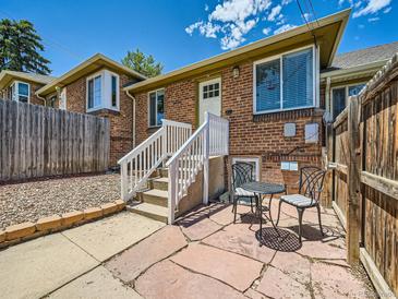 Charming brick home with a white front door, stairs, and a cozy patio set, perfect for outdoor relaxation at 4418 W 11Th Ave, Denver, CO 80204