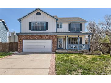 Charming two-story home featuring a brick-accented facade, inviting front porch, and well-maintained lawn at 9456 Bexley Dr, Highlands Ranch, CO 80126