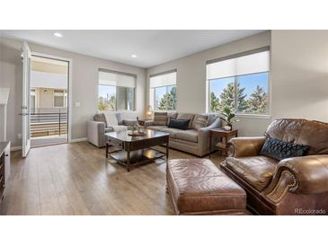 Inviting living room with stylish furniture, wood floors, and bright natural light from large windows at 4265 E Iliff Ave # 1, Denver, CO 80222