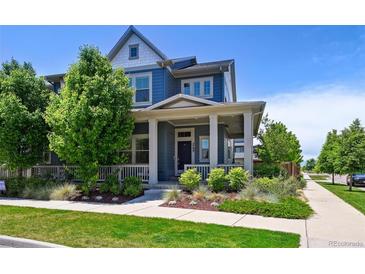 Charming two-story home with a covered front porch and beautifully landscaped front yard at 5799 Boston St, Denver, CO 80238