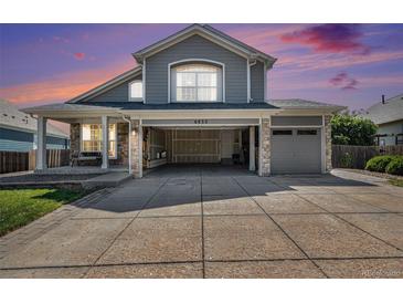 Charming two-story home featuring stone accents, a covered porch, open garage space, and a well-maintained lawn at 6833 E 115Th Ave, Thornton, CO 80233