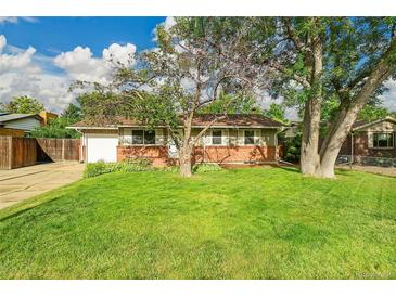 Charming single-story home with a well-manicured front lawn and mature trees at 1030 Kohl St, Broomfield, CO 80020