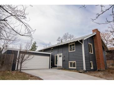 Charming two-story home with a brick chimney, attached garage, and a well-maintained yard at 2300 S Krameria St, Denver, CO 80222