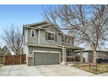 Charming two-story home with a well-maintained front yard and covered entry porch at 10529 Vaughn Way, Commerce City, CO 80022