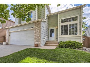 Charming two-story home with a two car garage, a well-manicured lawn, and lush landscaping at 9661 Autumnwood Pl, Highlands Ranch, CO 80129