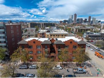 A stunning, vibrant daytime shot of a brick apartment building with a cityscape view including mountains and blue sky at 1475 N Humboldt St # 20, Denver, CO 80218