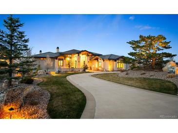 Stunning single Gathering home with a curved driveway and well manicured front yard landscaping at 703 Emberglow Ln, Highlands Ranch, CO 80126