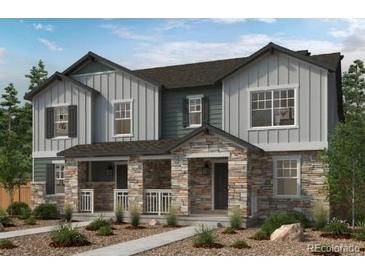 Charming two-story home featuring stone accents, a welcoming front porch, and neutral-colored siding at 24151 E 52Nd Ave, Aurora, CO 80019