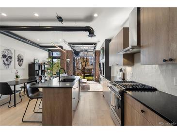 Modern kitchen featuring stainless steel appliances and a view to the outside patio area at 1242 Yates St # U2, Denver, CO 80204