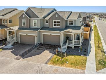 Attractive two-story home with gray siding, two-car garage, and charming covered porch at 700 Lillibrook Pl, Erie, CO 80026