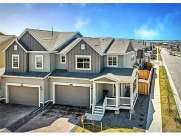 Charming townhome with two-car garage, covered porch, and neutral exterior paint in a well-maintained neighborhood at 700 Lillibrook Pl, Erie, CO 80026