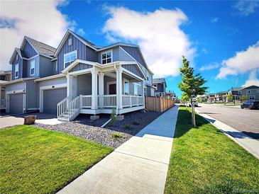 Beautiful home featuring manicured lawns and a cozy front porch perfect for relaxing outdoors at 700 Lillibrook Pl, Erie, CO 80026