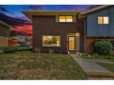 Charming brick home with well-maintained lawn and inviting entrance under a beautiful sunset sky at 8666 Mariposa St, Thornton, CO 80260