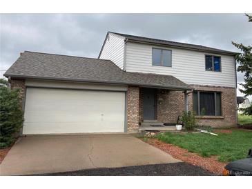 Two-story home with a brick and siding exterior, attached garage, and a well-maintained front lawn at 12904 N 3Rd St, Parker, CO 80134