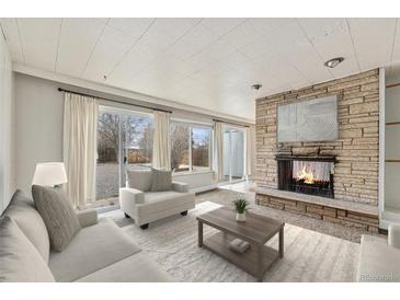 Cozy living room featuring a stone fireplace, sliding glass doors to the yard, and neutral finishes at 1355 Rosemary St, Denver, CO 80220